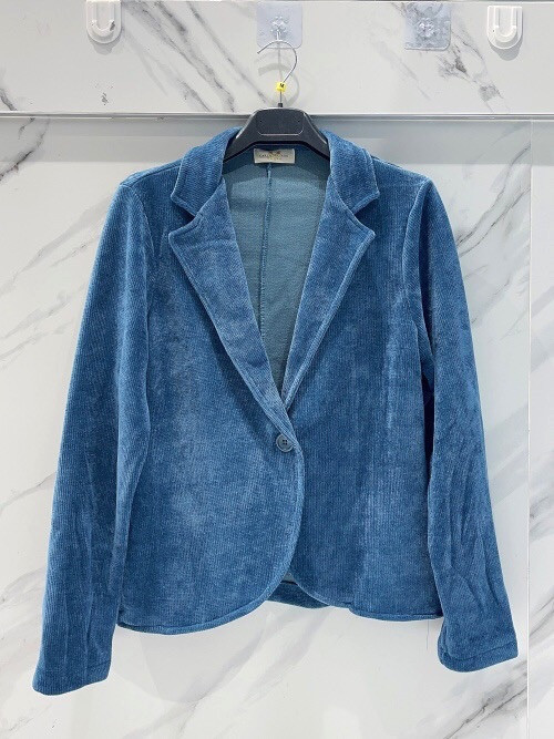 Veste souple en maille velours fermée par un bouton velours. Veste souple en maille velours fermée par un bouton velours.